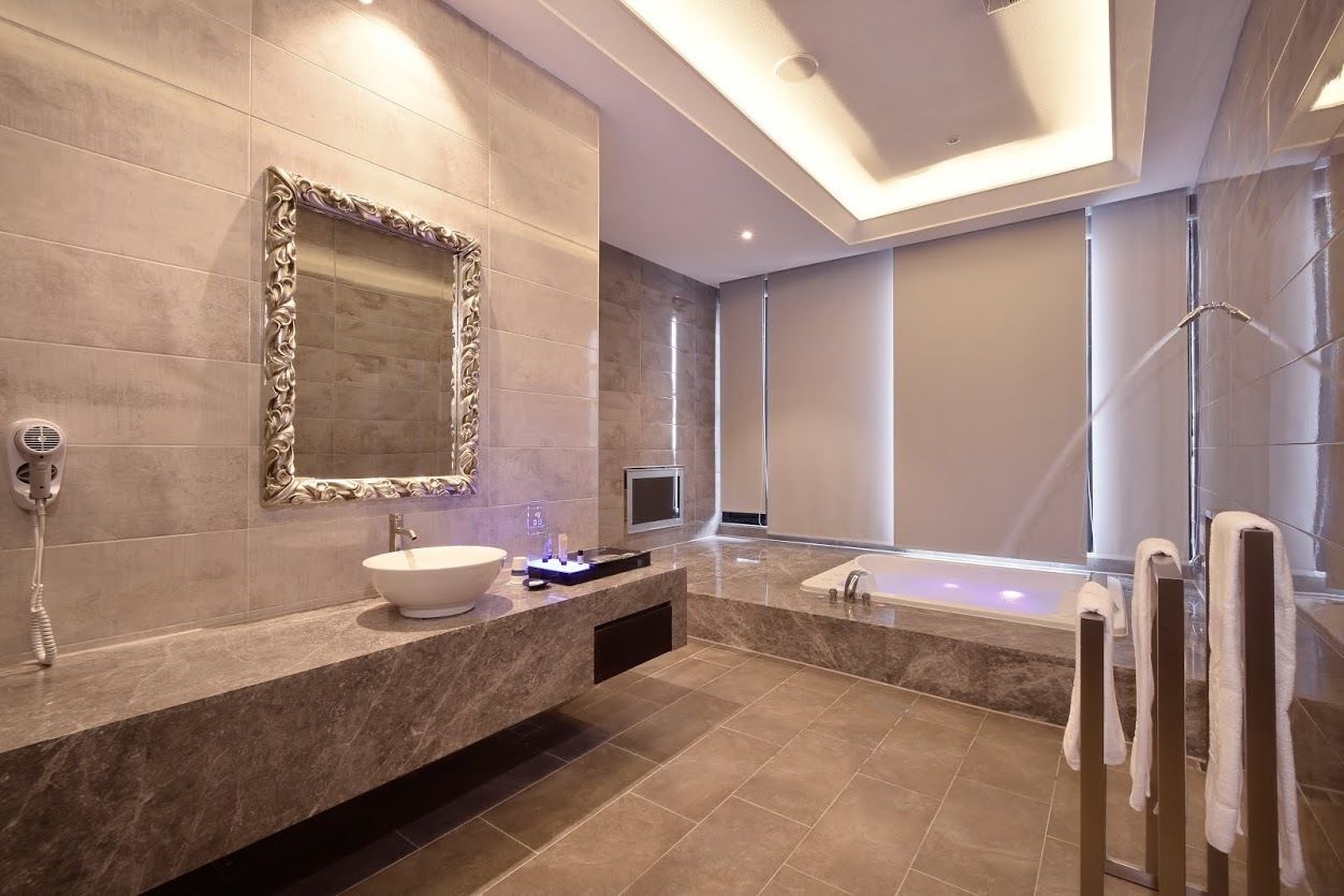 A modern bathroom with a large mirror, a vessel sink, a bathtub, and a glass shower enclosure.