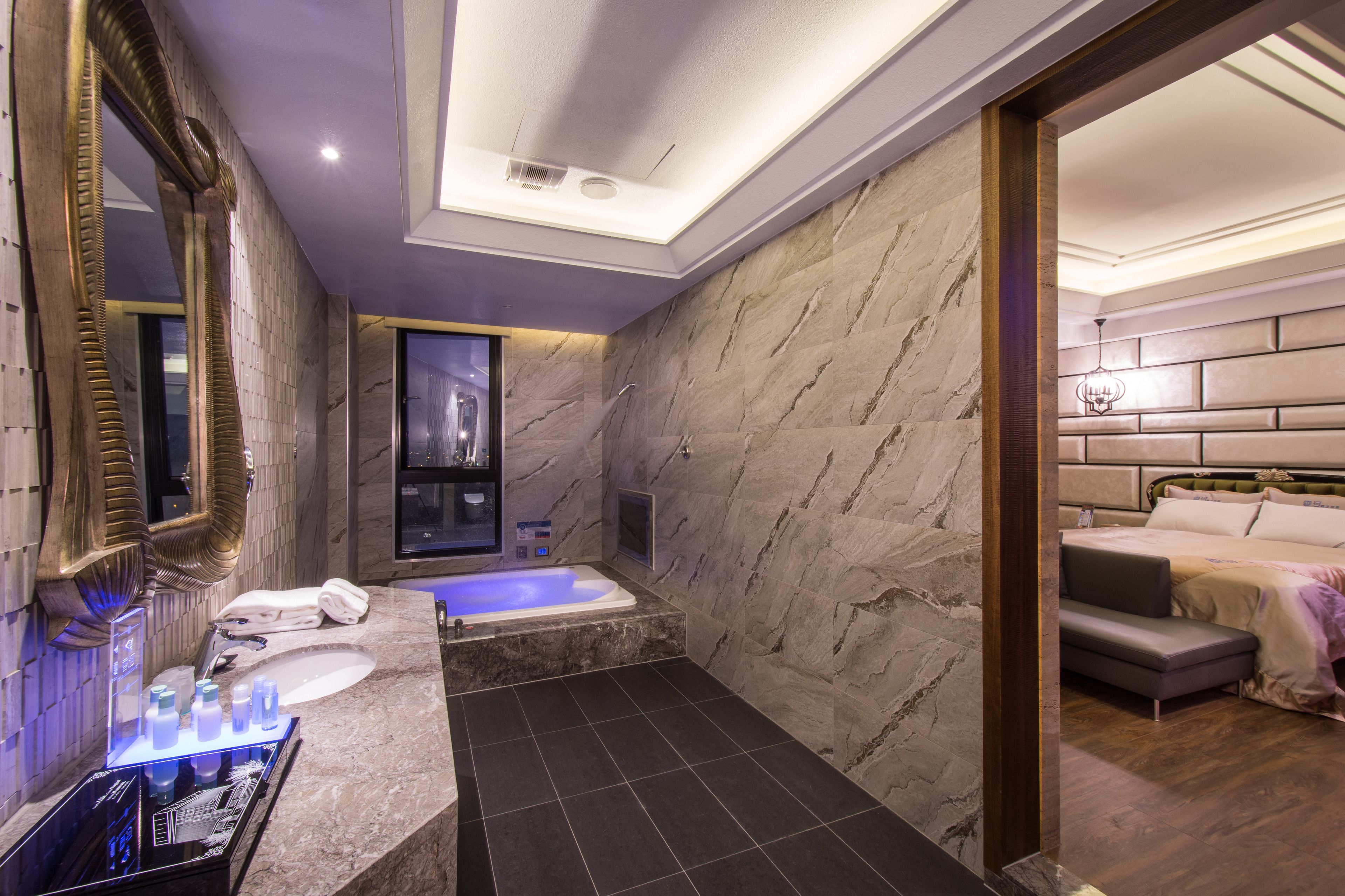 A modern bathroom with a large mirror, a bathtub, and a separate shower area.
