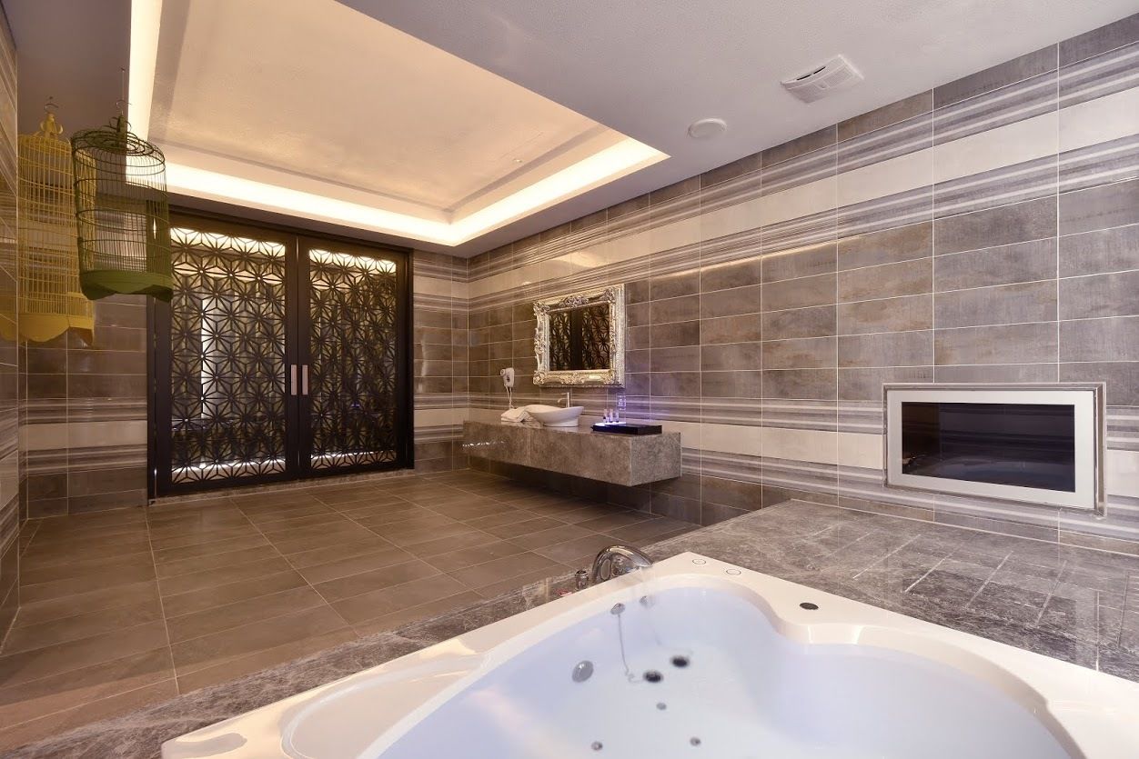 A modern bathroom with a large bathtub, a vanity with a mirror, and a decorative wall panel.