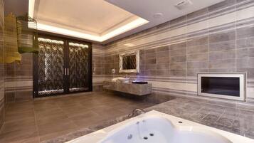 A modern bathroom with a large bathtub, a vanity with a mirror, and a decorative wall panel.