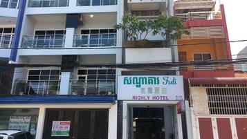 A multi-story building with a sign for "Fuli Richly Hotel" and a "Building For Rent" sign.