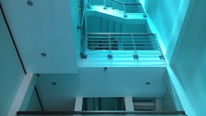 Un atrium à plusieurs niveaux, doté de rampes en verre et d’un espace central ouvert.