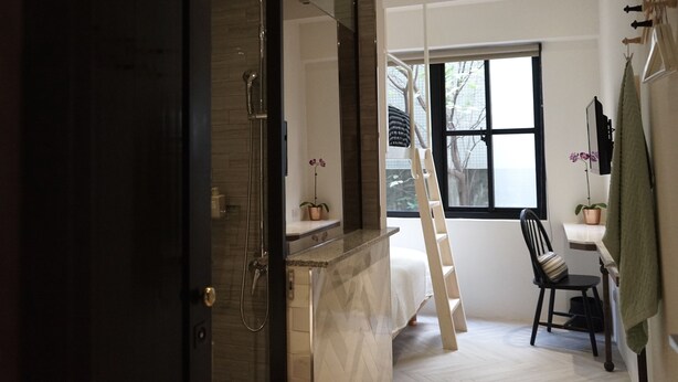 Uma casa de banho moderna com chuveiro, toucador com espelho e janela com vista para o exterior.