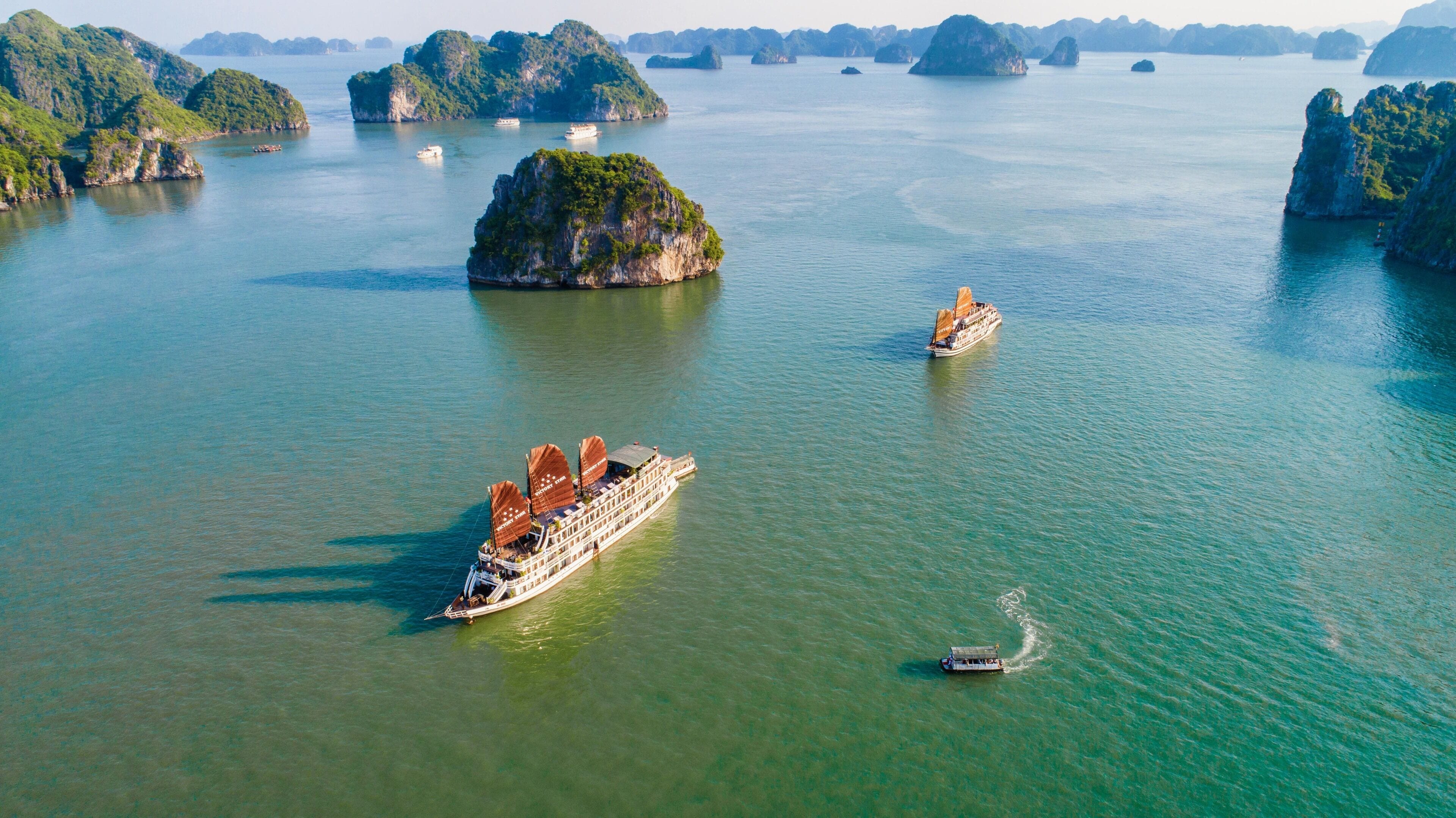 A large cruise ship with multiple decks and a smaller boat nearby.