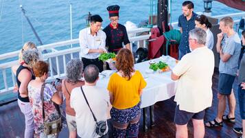 Un grupo de personas cenando en un barco con vistas al mar.