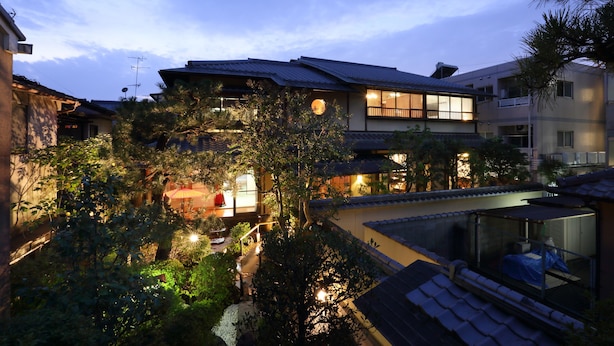 A traditional Japanese-style building with a well-lit garden area, a visible entrance, and a balcony with a view of the garden. - Kyo-machiya Stay WAKA Fushimiinari-tei (Kyoto)