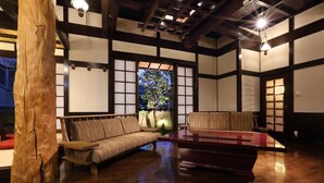 A traditional Japanese-style room with tatami flooring, a low wooden table, and a cushioned bench. - Kyo-machiya Stay WAKA Fushimiinari-tei (Kyoto)