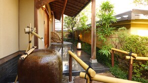 A traditional Japanese garden with a stone water feature, bamboo elements, and a wooden walkway. - Kyo-machiya Stay WAKA Fushimiinari-tei (Kyoto)