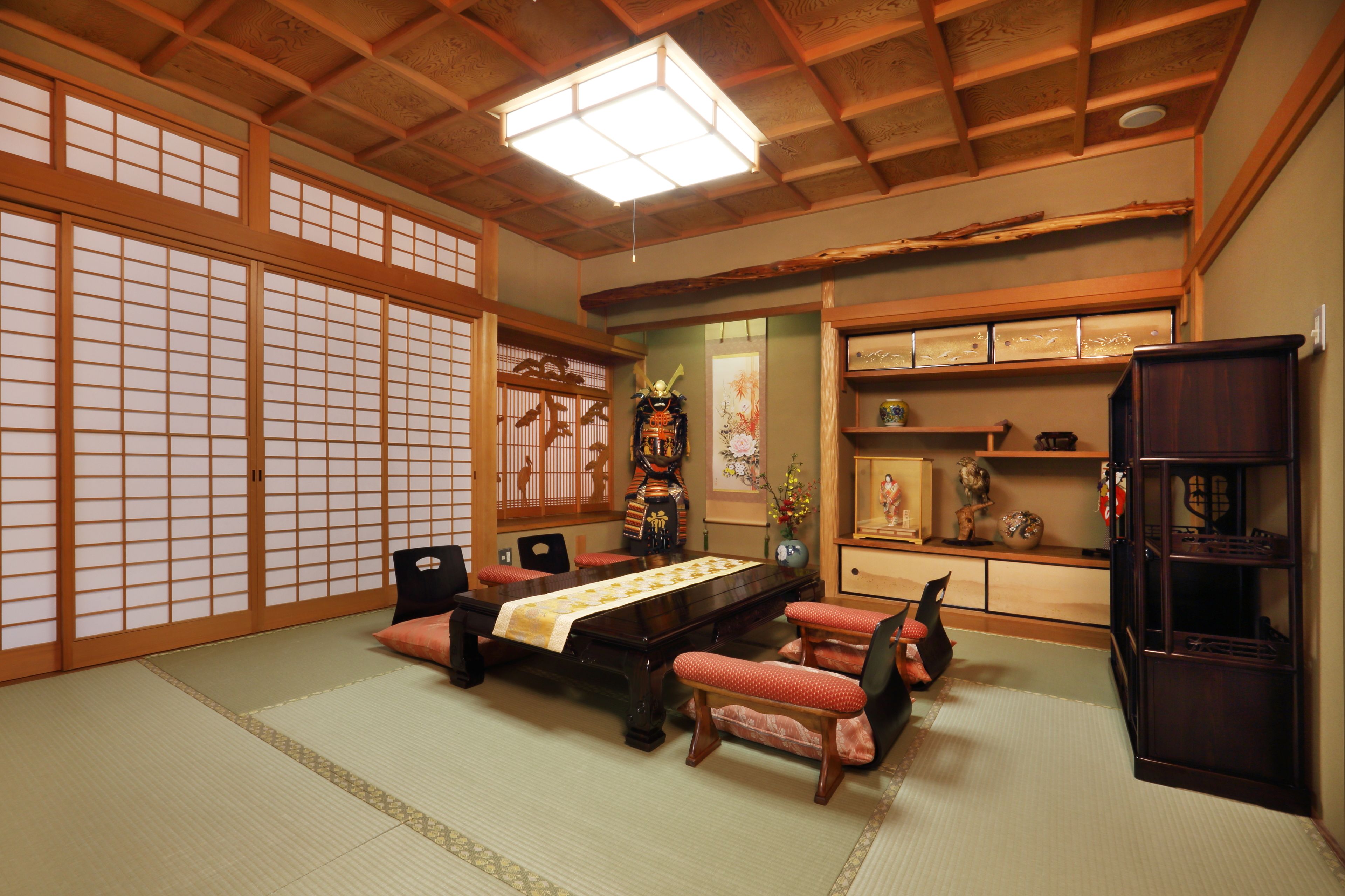 A traditional Japanese room with tatami flooring, a low table with cushions, and sliding doors.