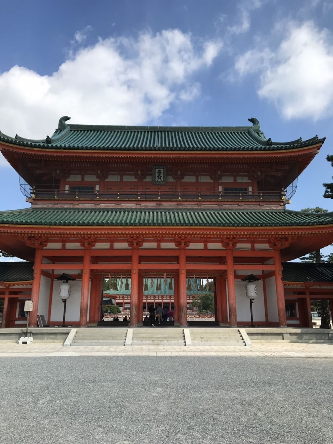 A traditional Japanese building with a multi-tiered roof and red pillars.