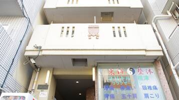 A multi-story building with a signboard displaying a business name and contact information.