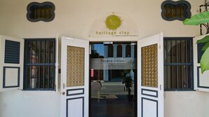 L’entrée de l’établissement Sarang Palon Heritage Stay, avec une enseigne indiquant le nom et le numéro de téléphone.