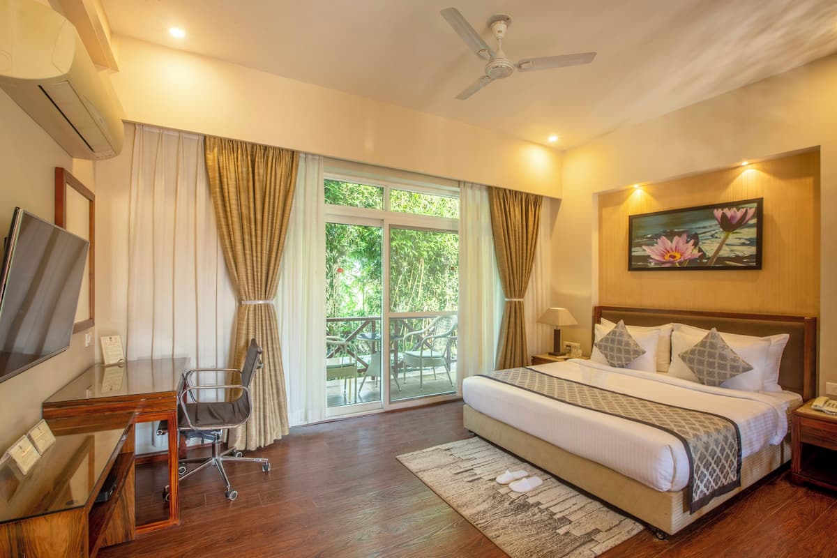 Une chambre d’hôtel avec un lit, un bureau, une chaise, une télévision et un tableau au mur.