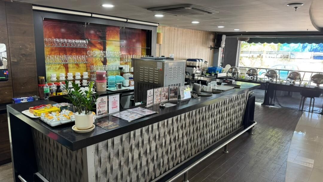 A reception area with a counter, glassware, and a coffee machine.