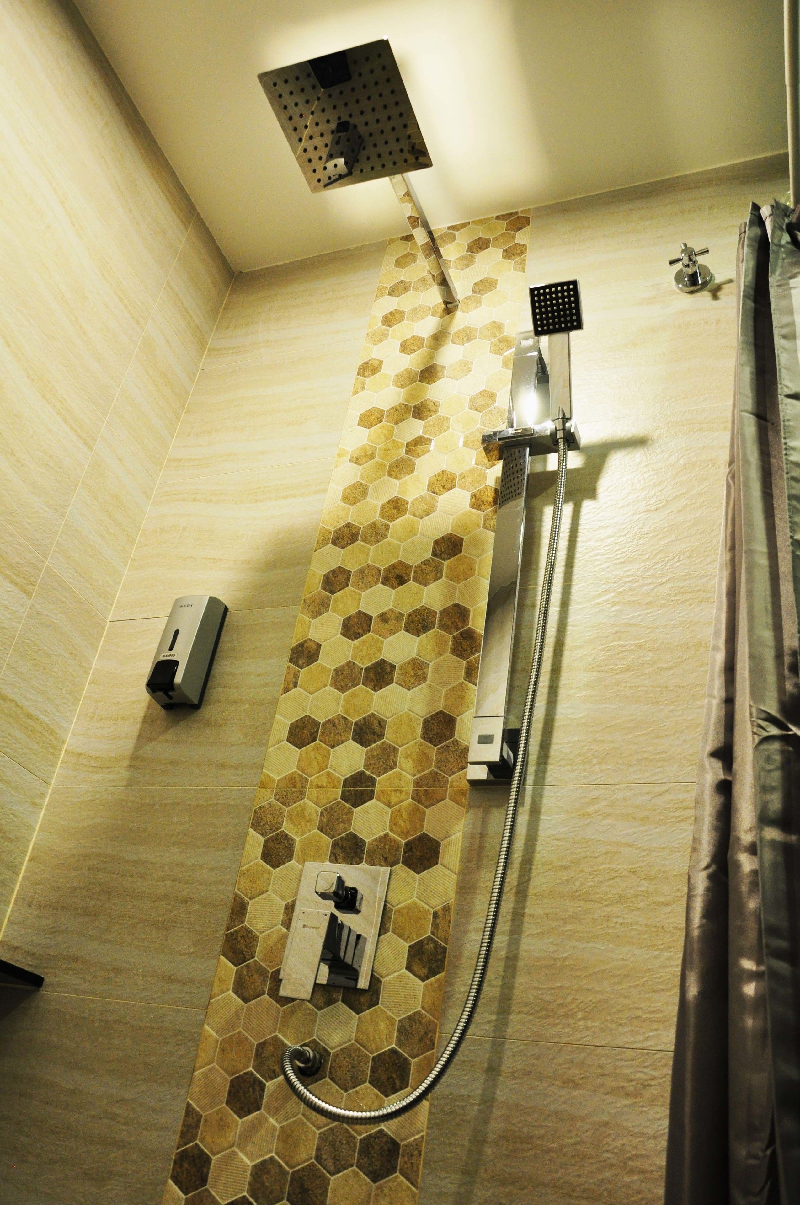 A shower with a rain showerhead, a handheld showerhead, and a handheld massager.