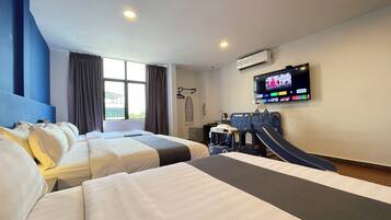 A hotel room with two beds, a TV, an air conditioner, and a children's play area.