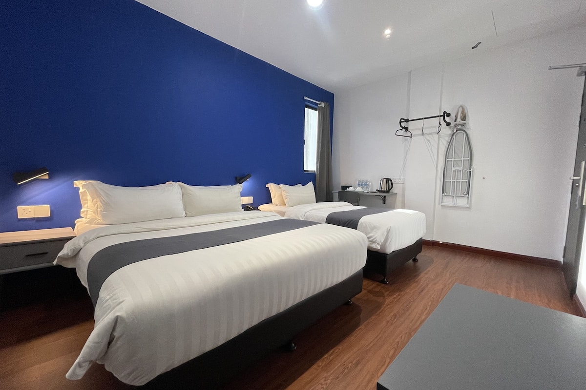 Une chambre d’hôtel moderne avec un grand lit, des tables de chevet, un bureau et une armoire.