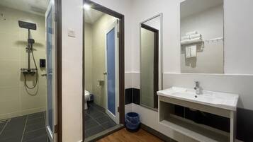 A modern bathroom with a shower, toilet, and sink.