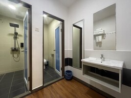 Un baño moderno con ducha, inodoro y lavamanos.