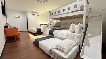 A modern hotel room with bunk beds, a desk, and a chair.