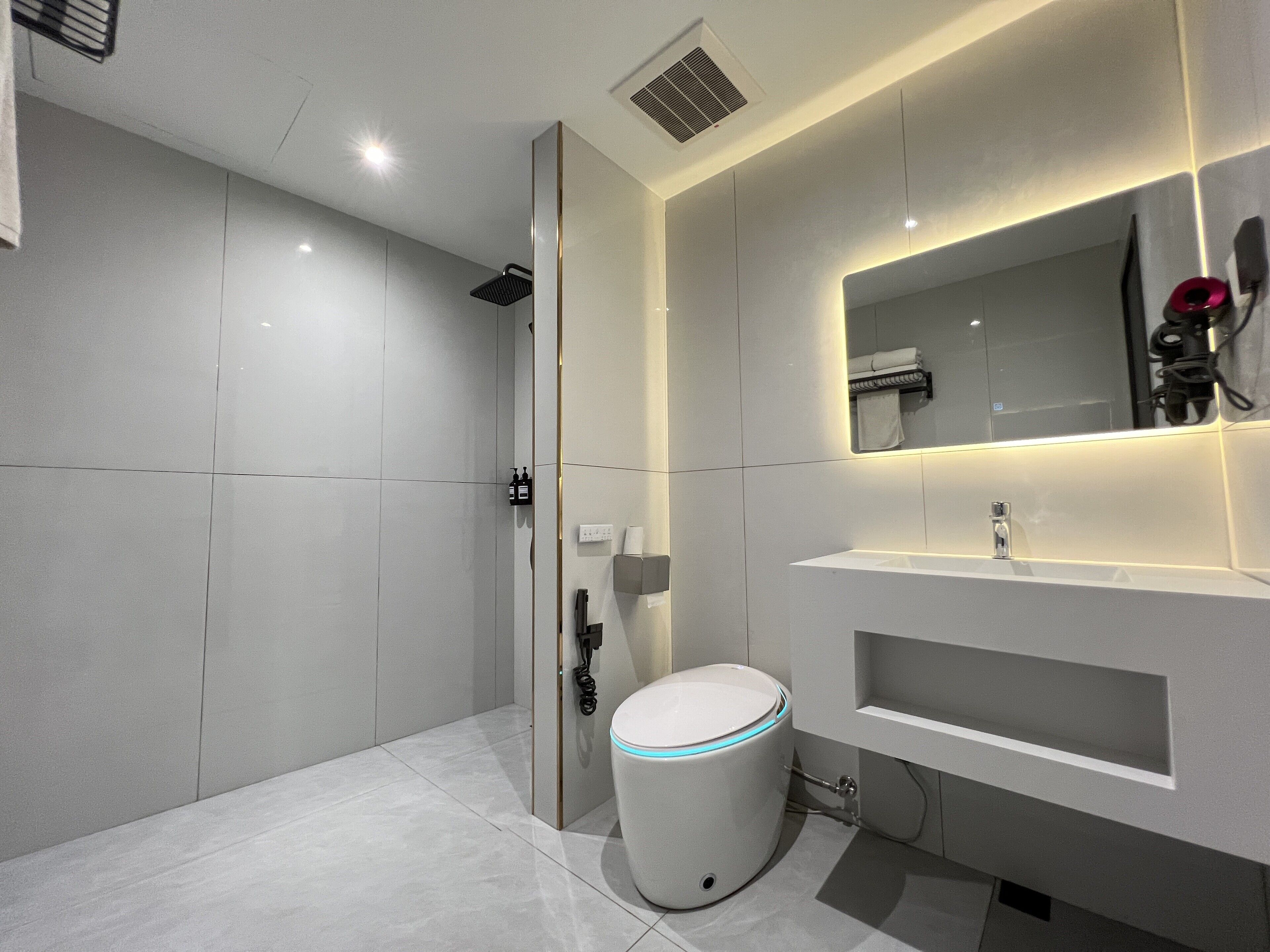 A modern bathroom with a toilet, sink, and shower.