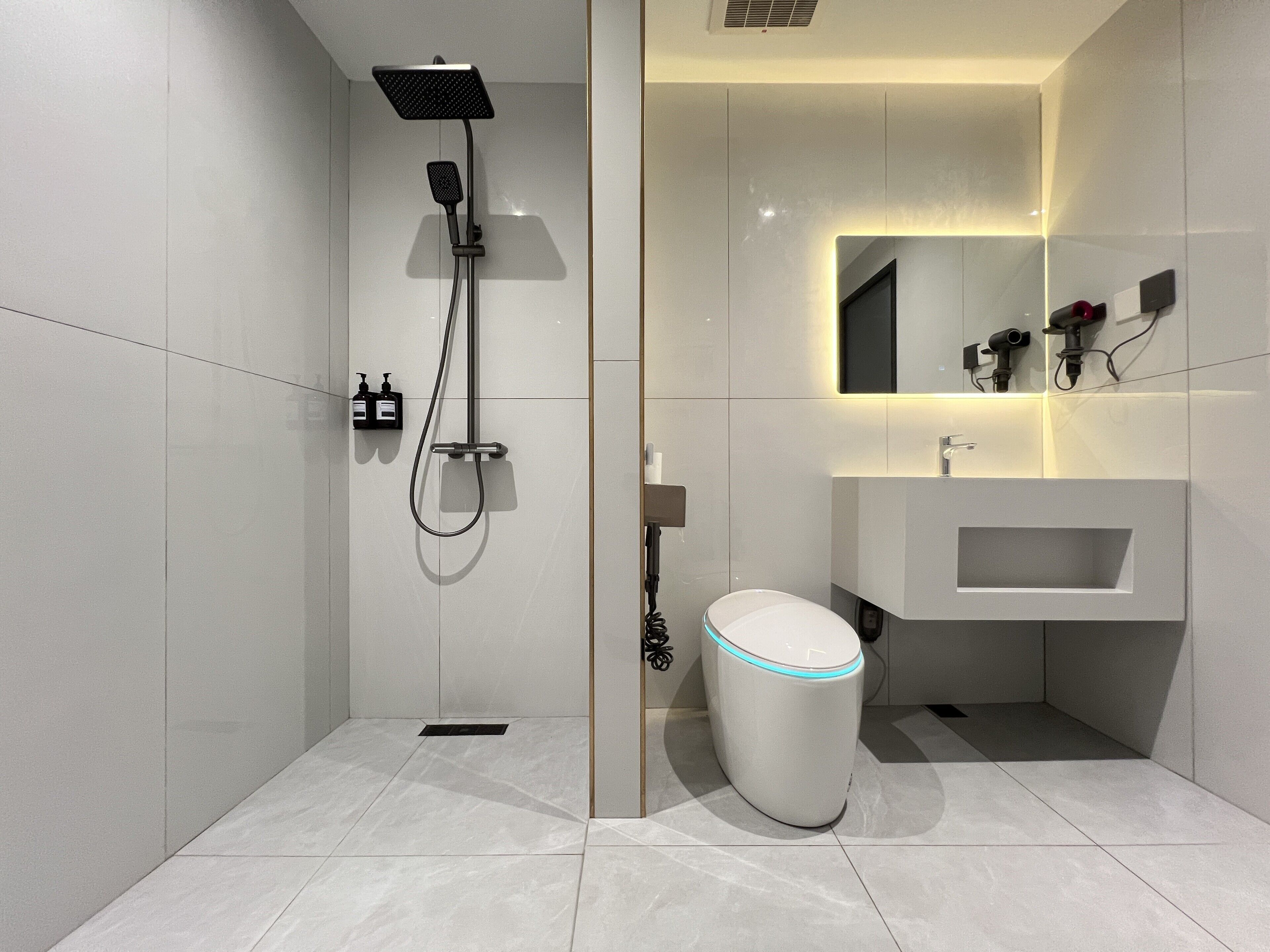 Un baño moderno con ducha, inodoro y tocador.