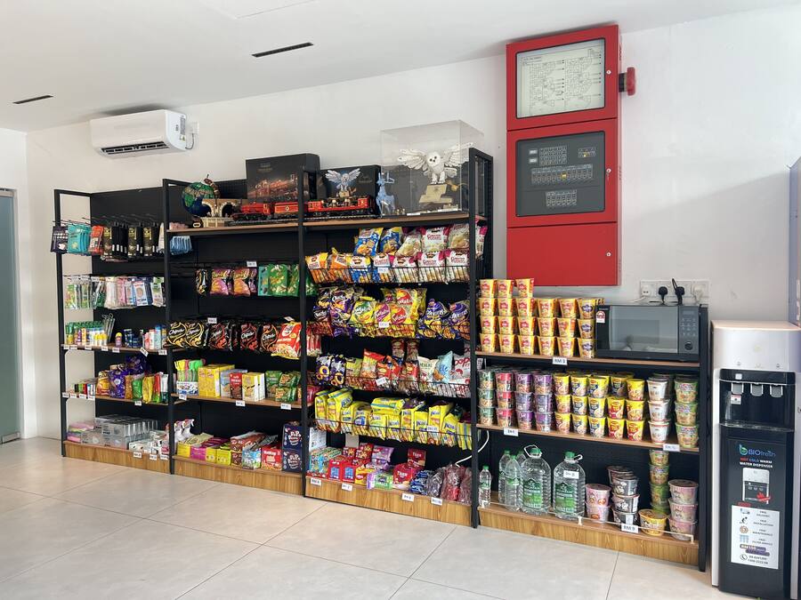 A grocery store with shelves stocked with snacks, beverages, and household items.
