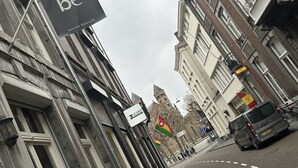 A street view with buildings, a flag, and a van. - Hotel BE41 (Maastricht)