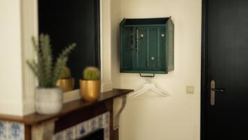 Een deur met een simpele deurklink, een witte kapstokhanger en een groene kast met slot.