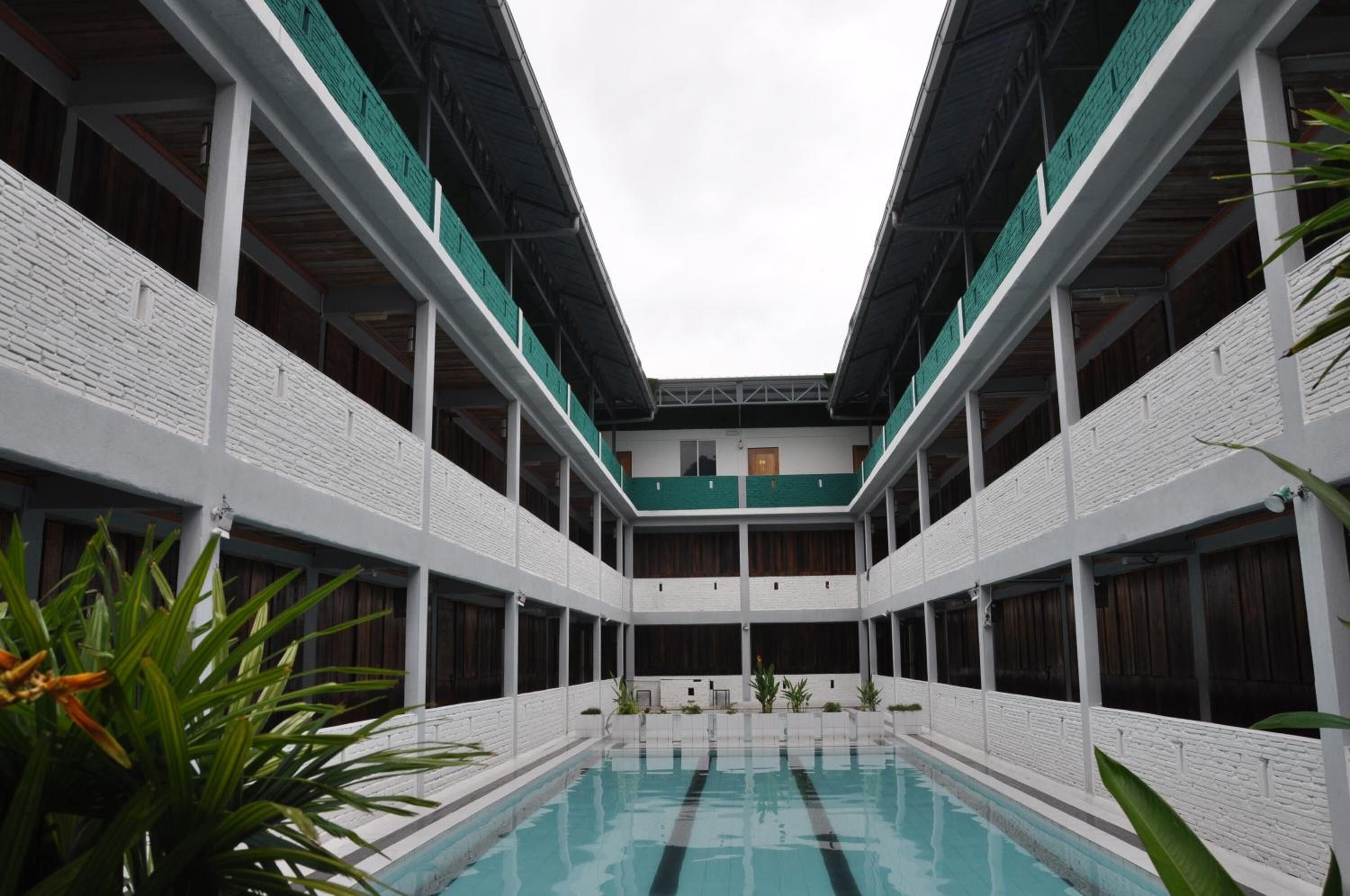 Un edificio de varios niveles con un patio central y una piscina.
