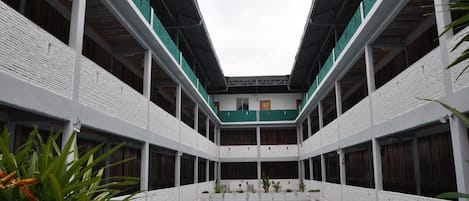 Un edificio de varios niveles con un patio central y una piscina.