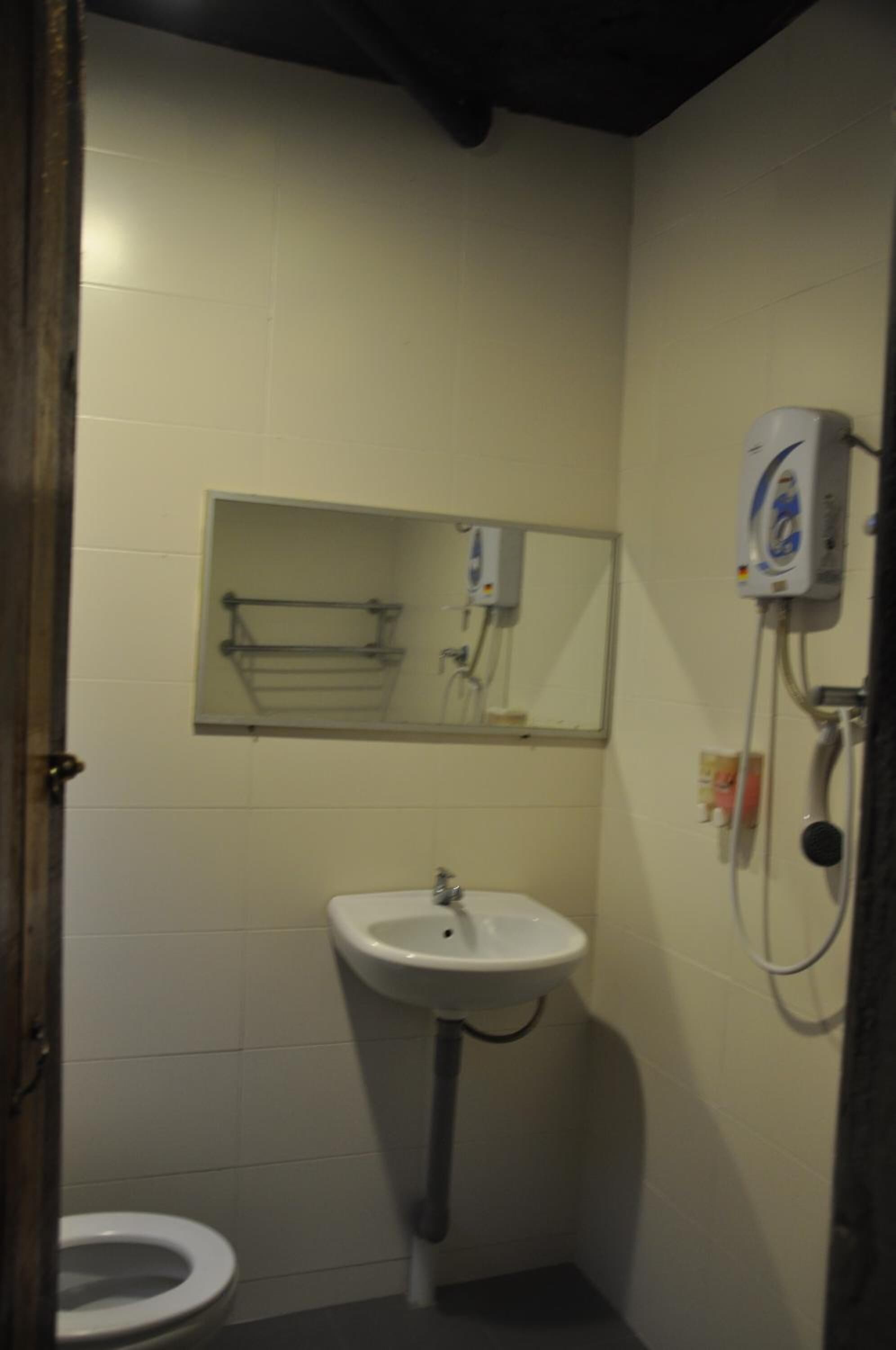 A small bathroom with a white sink, a toilet, and a mirror above the sink.