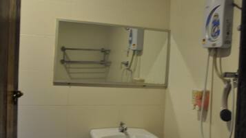 A small bathroom with a white sink, a toilet, and a mirror above the sink.