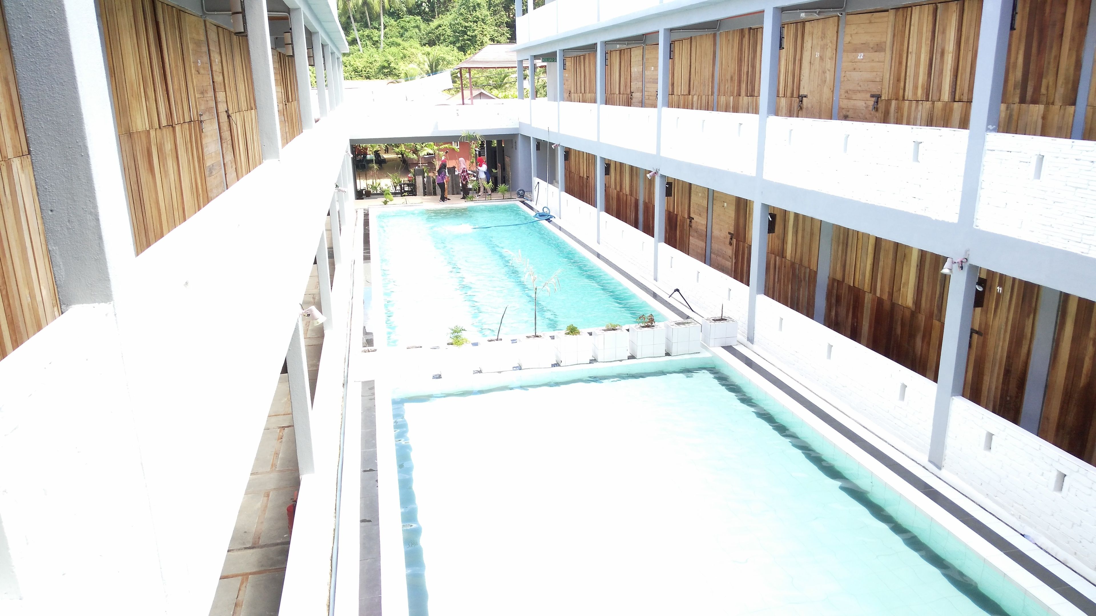 A pool area with a long, narrow pool and a covered seating area.