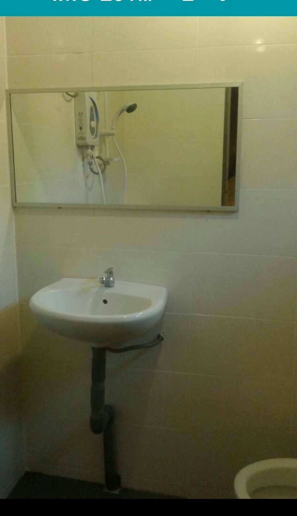 A bathroom with a white sink, a mirror above it, and a toilet to the right.