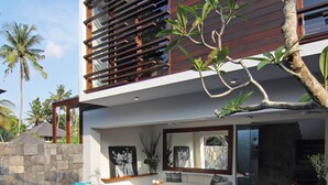 A modern house with a swimming pool, outdoor seating, and a large window overlooking the pool. - AbivillA Seminyak (Seminyak)