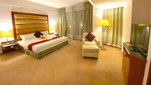 A hotel room with a bed, a chair, a desk, and a television. - Oriental Crystal Hotel Kajang (Kajang)