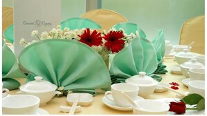 A table set with white teacups, teapots, and a menu card labeled "Oriental Crystal Hotel". - Oriental Crystal Hotel Kajang (Kajang)
