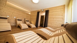 A sauna room with wooden benches and a visible door to the sauna area. - Hotel Elisabeth (Chienes)