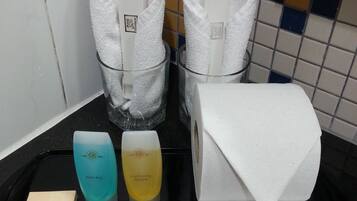 A tray with toiletries including a shower cap, cotton bud, foam bath, and conditioning shampoo.