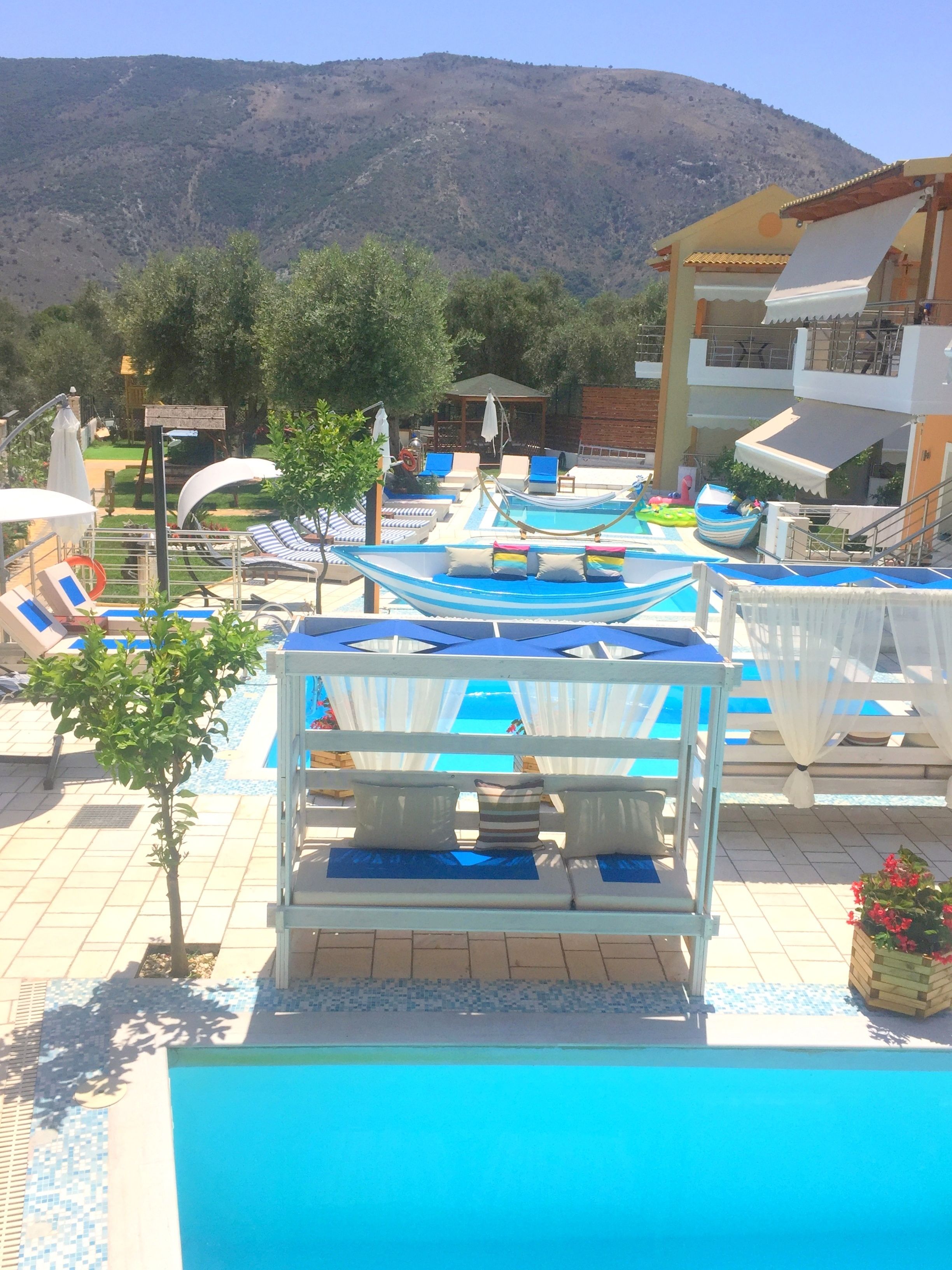 A pool area with lounge chairs and a view of a mountain.