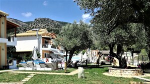 Un resort con piscina, sillas de descanso y un muro de piedra.