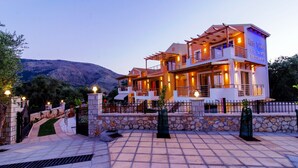 Un hotel de dos pisos con fachada de piedra, varios balcones y un letrero que dice 'All Saints Residences'.