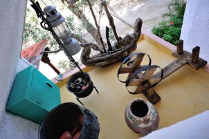 Un entorno rústico al aire libre con un bote de madera, un farol y diversos recipientes.