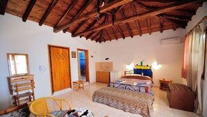A room with a bed, a desk, a chair, a suitcase, and a wardrobe. - Azalea Studios (Skiathos)