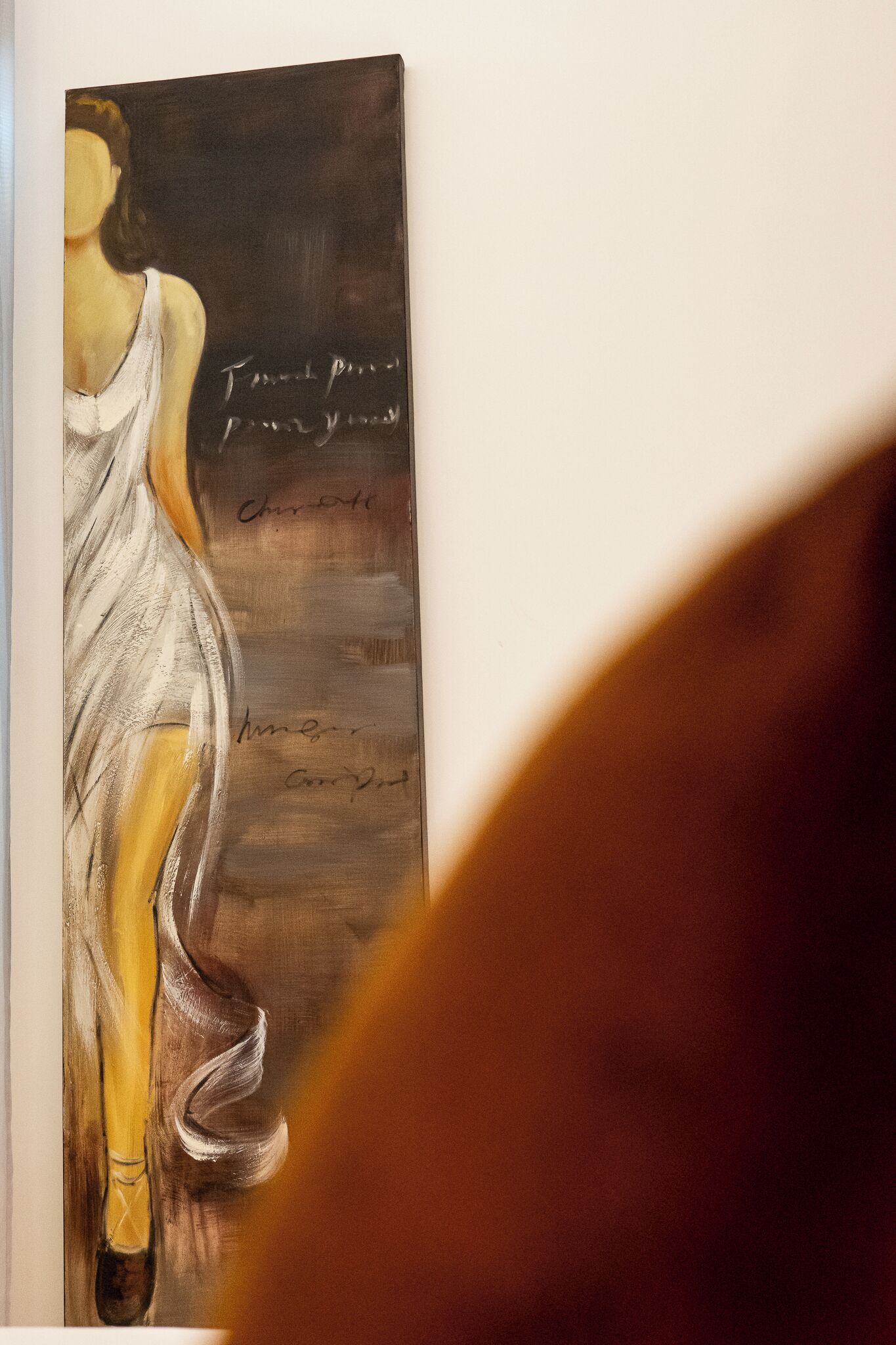 Una pintura de una mujer con un vestido blanco y texto en la pared detrás de ella.