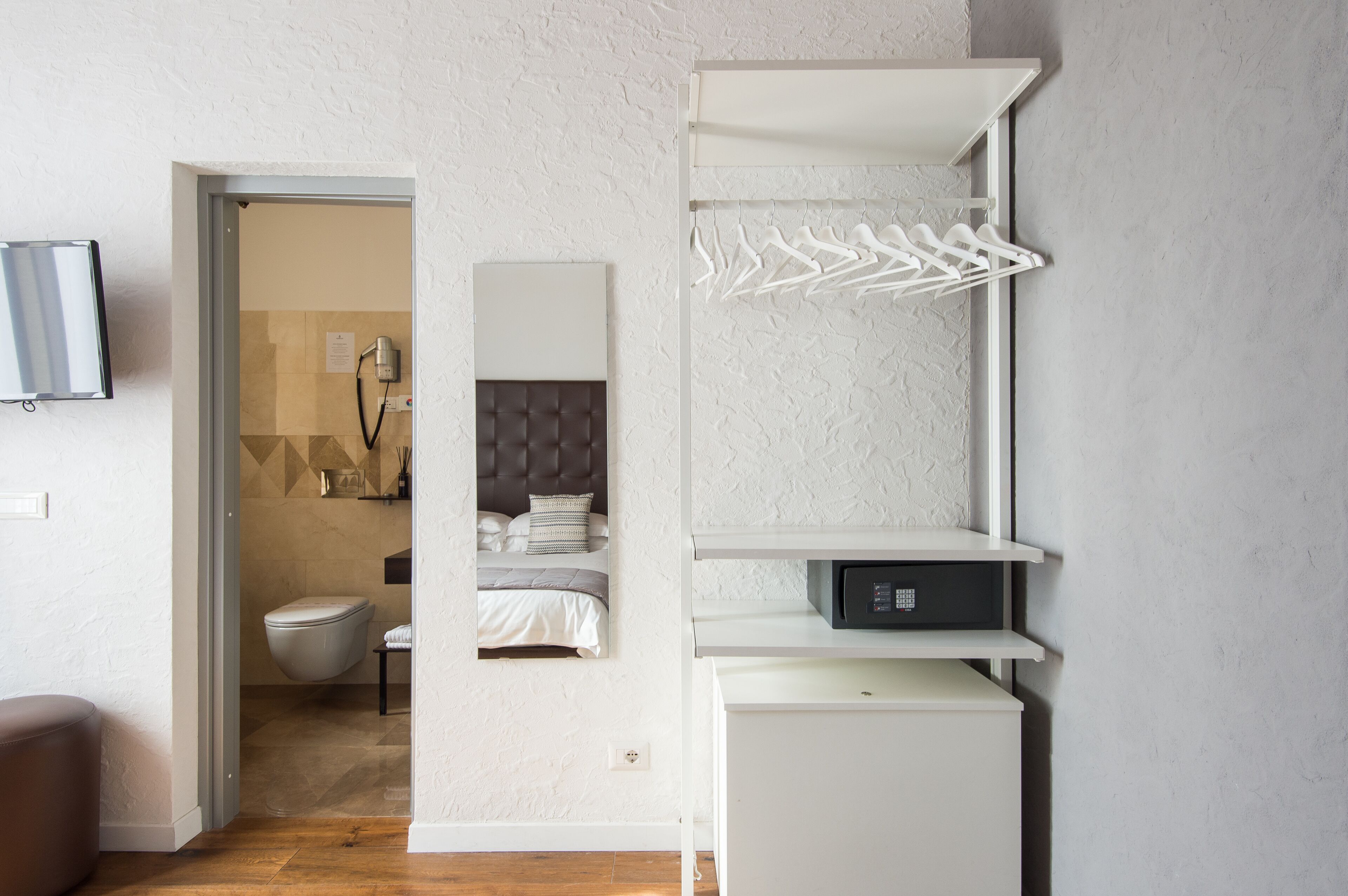 A modern bathroom with a toilet, bidet, and towel rack.