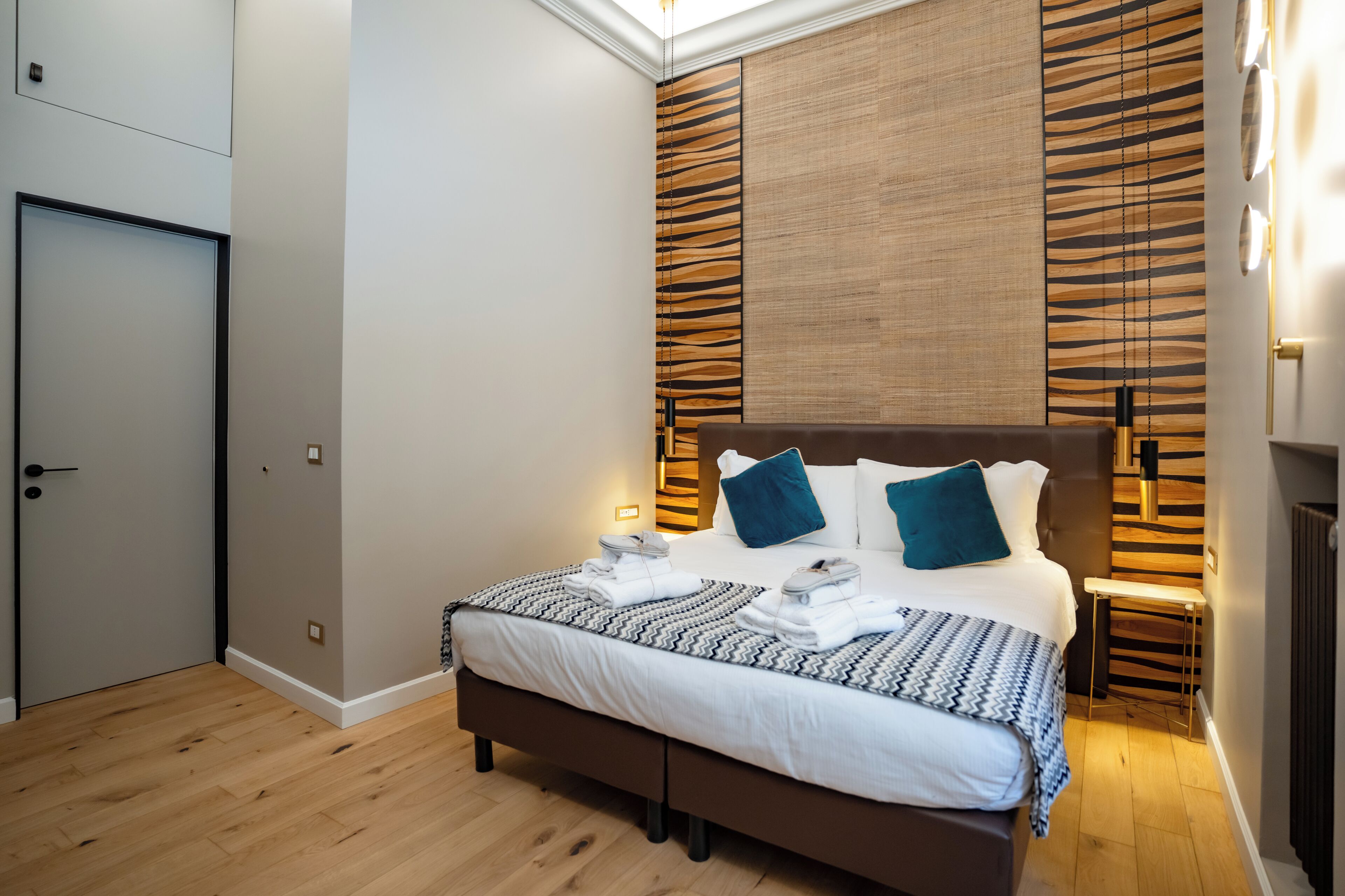 Une chambre moderne avec un grand lit, un mur lambrissé en bois et une lucarne.