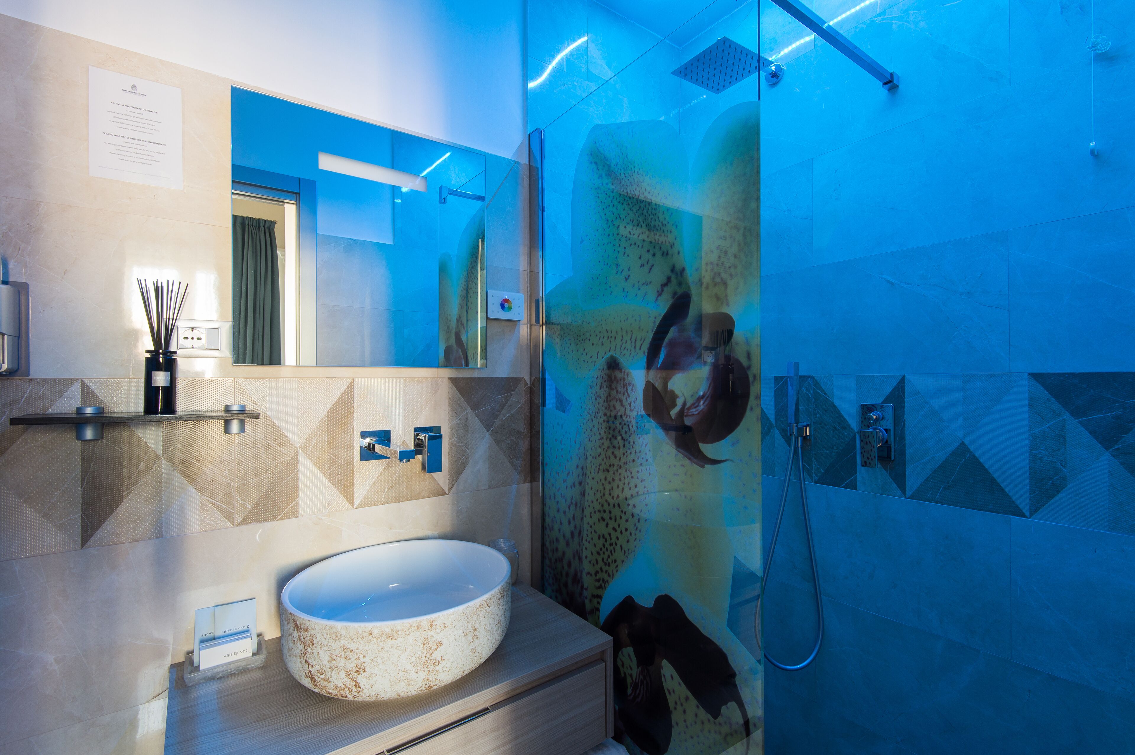 Une salle de bain moderne avec un lavabo rond, une douche en verre et un miroir.