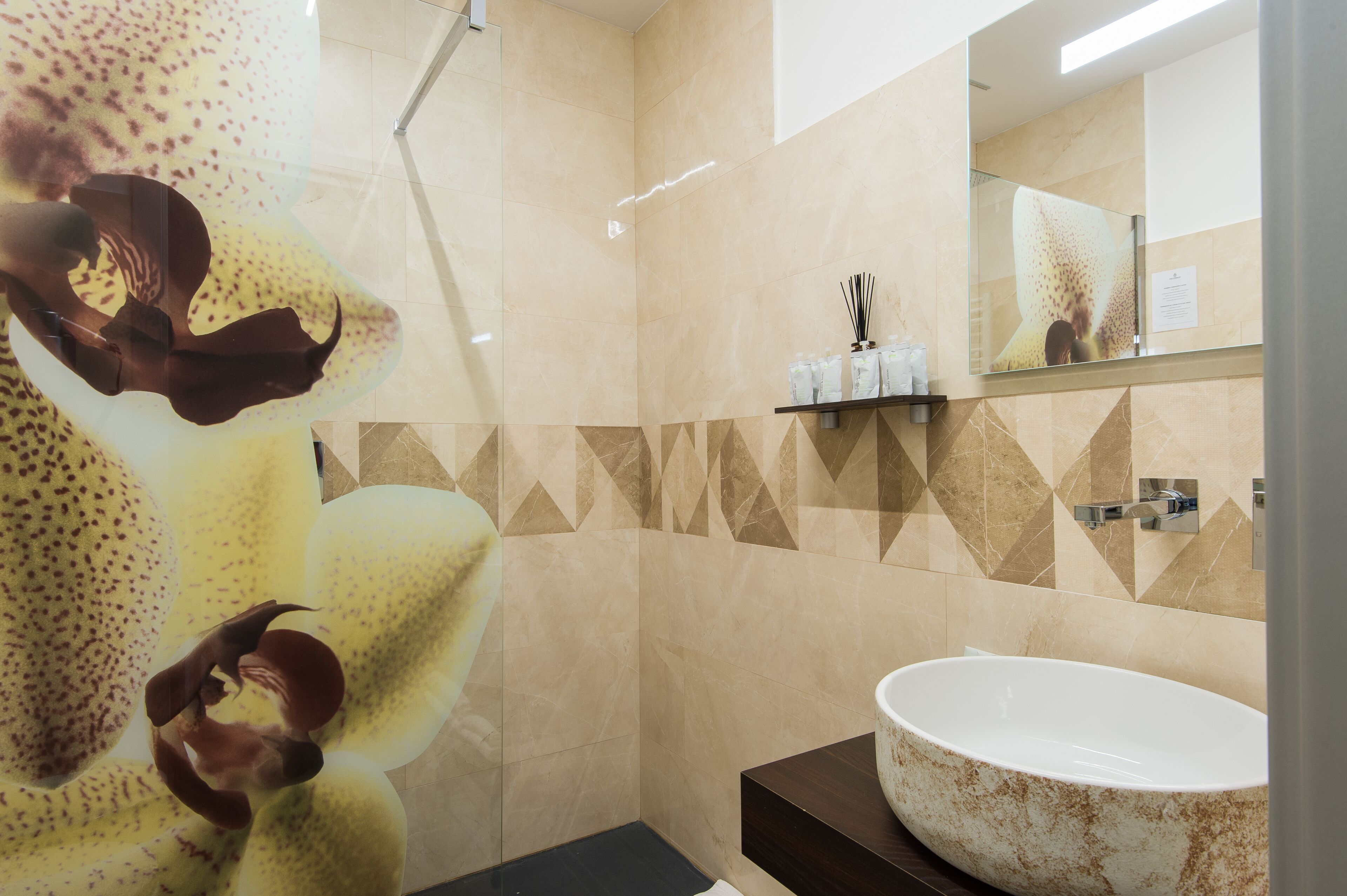 Ein modernes Badezimmer mit einem großen, ovalen Waschbecken, einer Dusche und einem Spiegel.